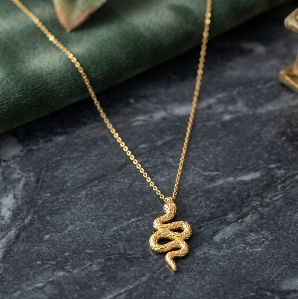 Close-up view of the Serpentina snake necklace crafted from sterling silver with 18K gold plating, showcasing the detailed serpent scales, zircon accents, and bold symbolic jewelry design.