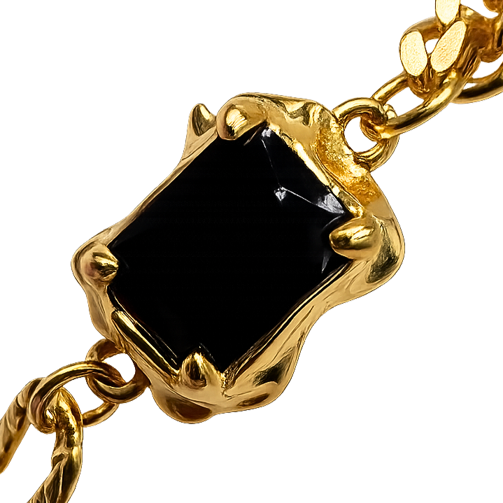 Detailed angle highlighting the polished gold-plated finish and sculptural stone setting.