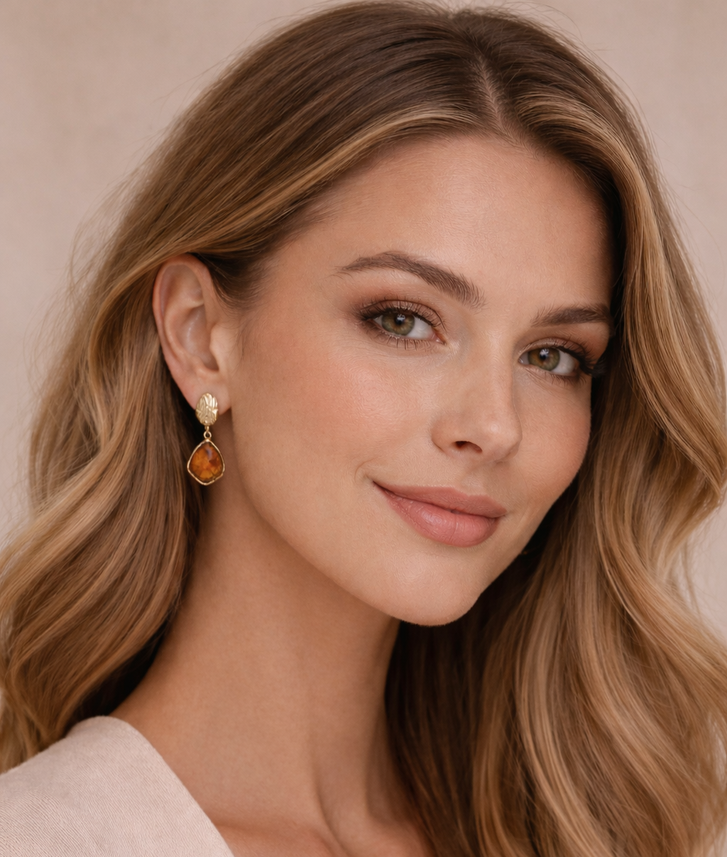 Front view photo of artistic gold earrings in a sculpted frame, showcasing a translucent vintage stone and the durability of stainless steel jewelry in true vintage earrings style.