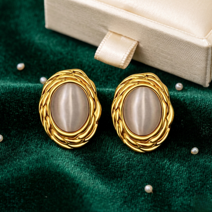 The Gia Cat’s Eye stud earrings displayed in a full-face lifestyle portrait, emphasizing their elegant elongated silhouette and vintage-inspired design. Crafted from 18k gold plated stainless steel with luminous cat’s eye stones, these luxury stud earrings add a polished statement while remaining timeless, sophisticated, and effortlessly wearable.
