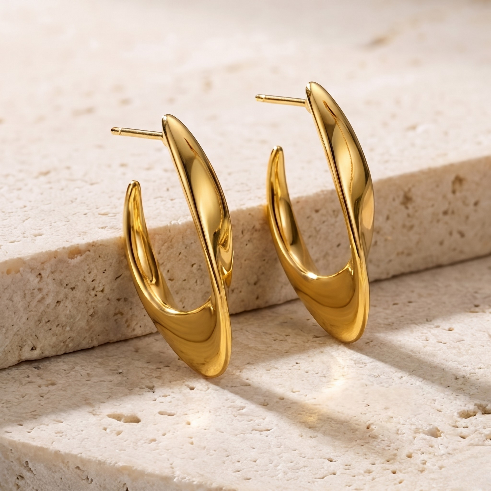 Elegant close-up of the Luna Curve hoop earrings in radiant 18K gold plated finish, crafted from premium S925 sterling silver jewelry. The sculptural crescent silhouette and polished gold shine create a bold yet timeless statement.