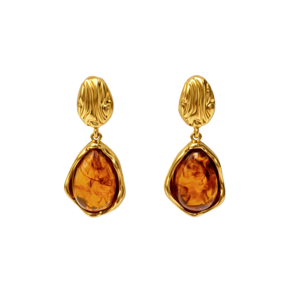 Close-up photo of elegant gold earrings crafted from stainless steel jewelry, featuring a warm vintage stone set in an organic gold frame, inspired by timeless vintage earrings design