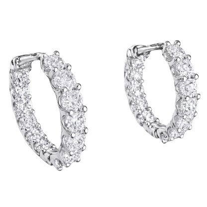 Close-up of GRA certified moissanite diamonds with VVS1 clarity set in rhodium plated silver hoops.