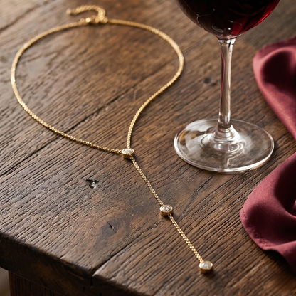 Close-up of Angela 14k gold plated sterling silver lariat necklace featuring brilliant zircon accents and delicate drop chain for timeless minimalist jewelry style.