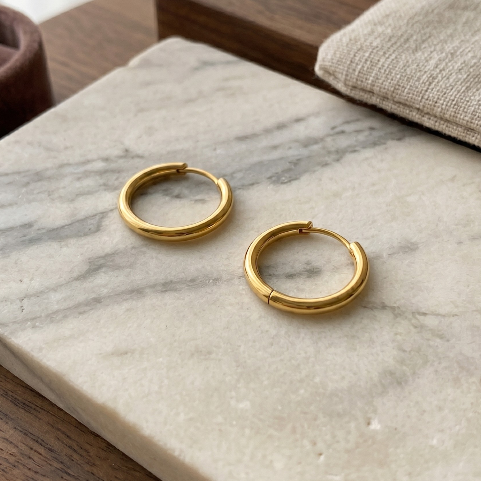 Detailed image of S925 sterling silver earrings with smooth 18K gold plating and refined thin hoop form.